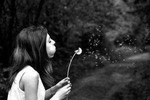 Woman making wish on dandelion